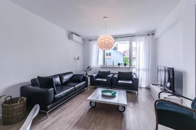 a living room with black leather furniture and a tv at 66 Apartment - Stylish Two Bedroom in Lozenets District by Flat Mаnager in Sofia