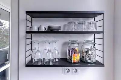 a shelf with glass jars and dishes on it at 66 Apartment - Stylish Two Bedroom in Lozenets District by Flat Mаnager in Sofia
