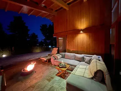 a living room with a couch and a fire pit at Pirin Golf and Spa Luxury Chalet in Bansko