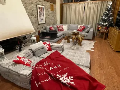 a living room with a couch and a christmas tree at Pirin Golf and Spa Luxury Chalet in Bansko