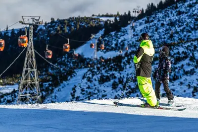 a couple of people on skis on a ski lift at Studios-Villa Park SV in Borovets