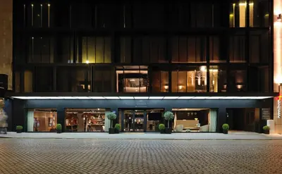 a large building at night with potted plants in front at Sense Hotel Sofia, a Member of Design Hotels in Sofia