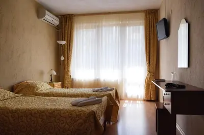 a hotel room with two beds and a window at СТАИ ЗА ГОСТИ МЗ-ДЕВИН in Devin