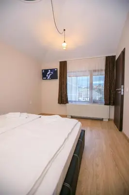 a hotel room with two beds and a window at Апартаменти Принц и Принцеса in Sandanski