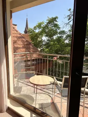 a patio with a table and chairs on a balcony at Clepsydra Residence in Plovdiv