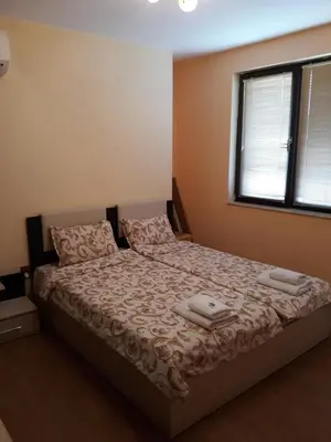 a bedroom with a bed with two towels on it at Апартамент ТЕА in Sandanski