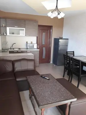 a living room and kitchen with a couch and a table at Апартамент ТЕА in Sandanski