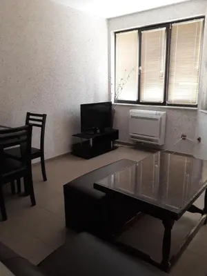 a living room with a coffee table and a window at Апартамент ТЕА in Sandanski