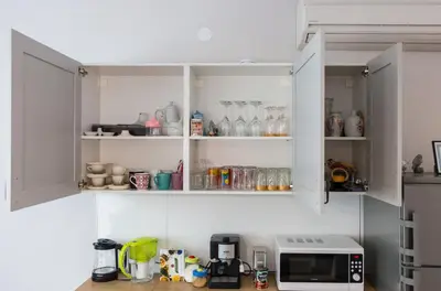 a kitchen with white cabinets and a microwave at Bright and Cozy 2BD Flat in Plovdiv City Centre by Flat Mаnager in Plovdiv