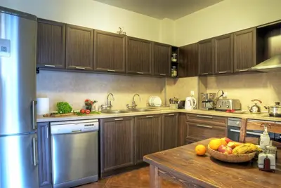 a kitchen with wooden cabinets and a bowl of fruit on a table at The Poppies House in Pamporovo