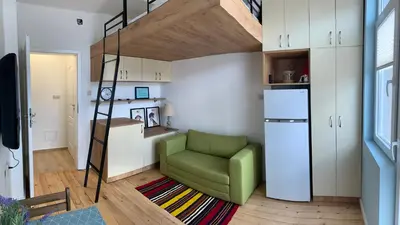 a living room with a green chair and a loft bed at Campbell's central apartment in Sofia