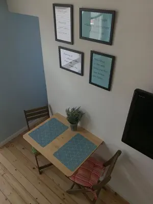 a table and a chair in a room with a tv at Campbell's central apartment in Sofia