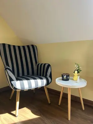 a striped chair and a side table in a room at Roma Apartment in Sandanski