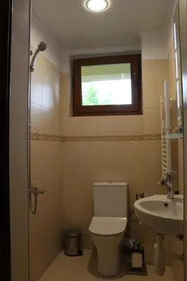 a bathroom with a toilet and a sink and a window at Urban House in Sofia