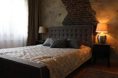 a bedroom with a large bed with a brick wall at Urban House in Sofia