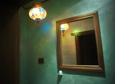 a bathroom with a mirror and a chandelier at The FlyingTheatre Suites in Plovdiv