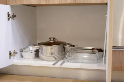 a cabinet with a pot and pans on a shelf at The Place -Apartments in Plovdiv, with private parking in Plovdiv