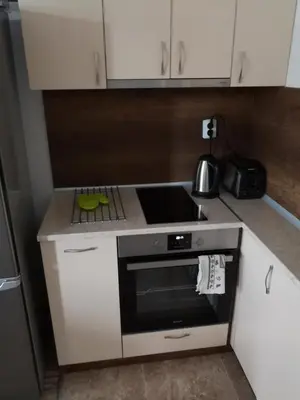 a kitchen with white cabinets and a black oven at Business and Leisure apartments in Mladost 2 with FREE Garage in Sofia