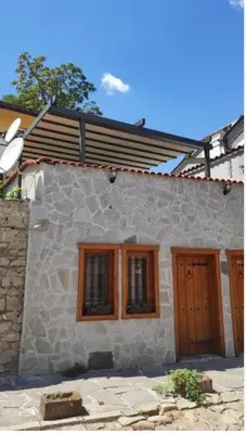 a stone house with wooden doors and windows at Marchevi in the Old Town in Plovdiv