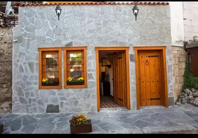 a stone house with wooden doors and windows at Marchevi in the Old Town in Plovdiv
