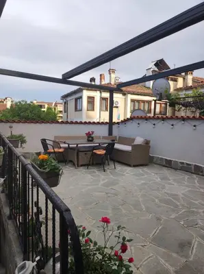 a patio with a table and chairs on a house at Marchevi in the Old Town in Plovdiv