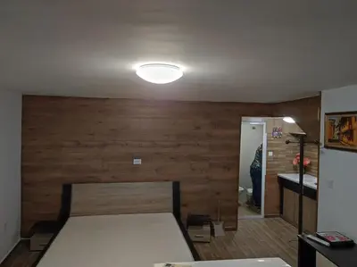 a bedroom with a bed with a wooden wall at Marchevi in the Old Town in Plovdiv