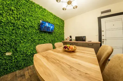 a dining room with a table and a green wall at Sofia Crown Life Apartment in Sofia