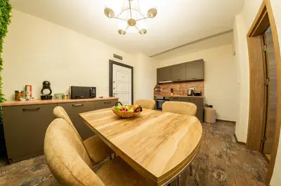 a kitchen and dining room with a wooden table and chairs at Sofia Crown Life Apartment in Sofia