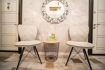 two chairs and a table in front of a mirror at Sofia Colour Life Apartment -No Window Apartment in Sofia
