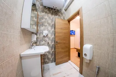 a bathroom with a sink and a mirror and a door at Sofia Industrial Life Apartment in Sofia