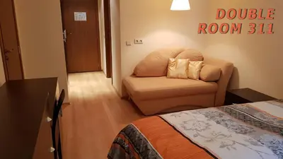 a bedroom with a couch and a chair in a room at Villa Park Studio&Double room in Borovets