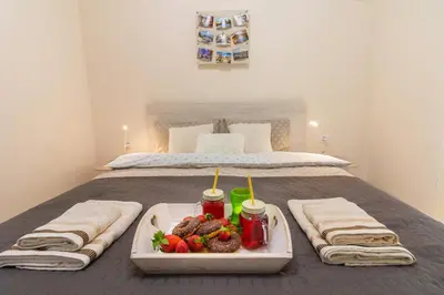 a bedroom with a bed with a tray of food on it at Domus Apartments Grand with Parking in Plovdiv