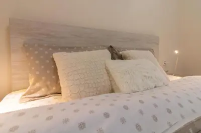 a bed with white sheets and pillows on it at Domus Apartments Grand with Parking in Plovdiv