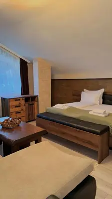 a bedroom with a large bed and a table at Deluxe 707 in Borovets