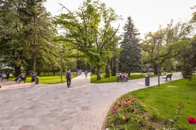 a park with people sitting and walking on a sidewalk at CACAO Studio next to Crystal Garden and Russian Church by Flat Mаnager in Sofia