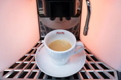 a cup of coffee on a plate on a table at B1 Boutique Hotel Sofia in Sofia