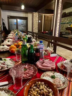 a long table with plates of food and drinks at Къща за гости Александра in Dobrinishte