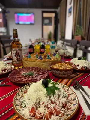 a table with plates of food on a table at Къща за гости Александра in Dobrinishte