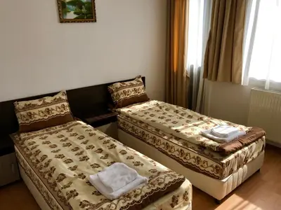 a hotel room with two beds with towels on them at Къща за гости Александра in Dobrinishte