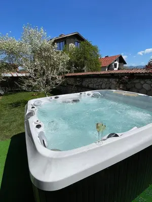 a jacuzzi tub with a glass in a yard at Къща за гости Александра in Dobrinishte