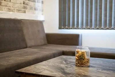 a glass jar on a table next to a couch at Sofia Downtown Life Apartment in Sofia
