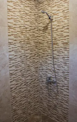 a shower in a bathroom with a brick wall at Apartment Petya in Velingrad