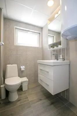 a bathroom with a toilet and a sink and a window at Sunpark Apartment in Sandanski