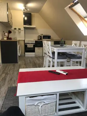 a kitchen and living room with a white table and chairs at Sunpark Apartment in Sandanski