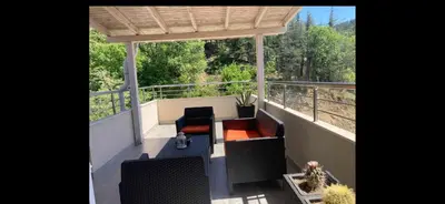 a balcony with a table and chairs and trees at Sunpark Apartment in Sandanski