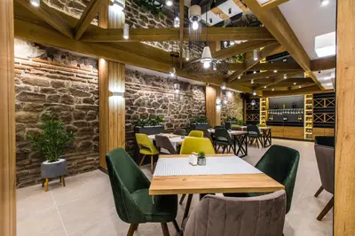 a restaurant with tables and chairs and a stone wall at HillHouse Plovdiv in Plovdiv