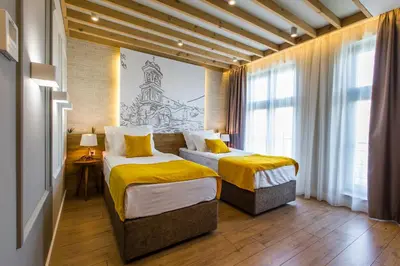 a hotel room with two beds and a drawing on the wall at HillHouse Plovdiv in Plovdiv