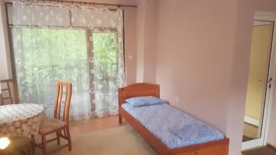 a bedroom with a bed and a table and a window at Вила Керенски in Ribarica