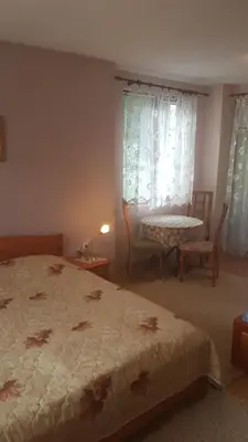 a bedroom with a bed and a table and a window at Вила Керенски in Ribarica