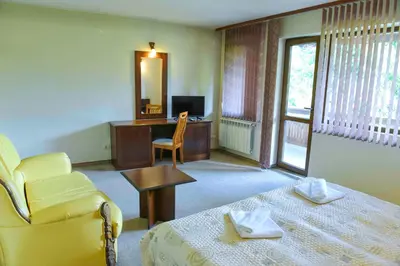 a room with a bed and a desk and a chair at Lovna sreshta in Bansko